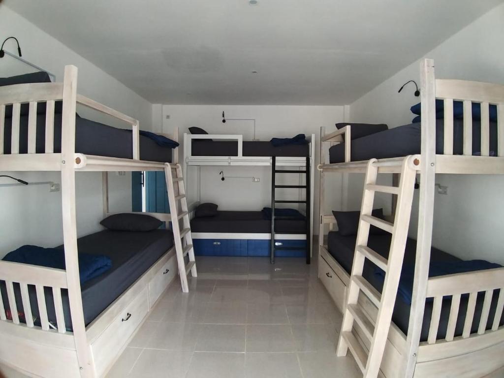 a dorm room with three bunk beds in it at Anjo Maumere Hotel & Restaurant in Nangalima