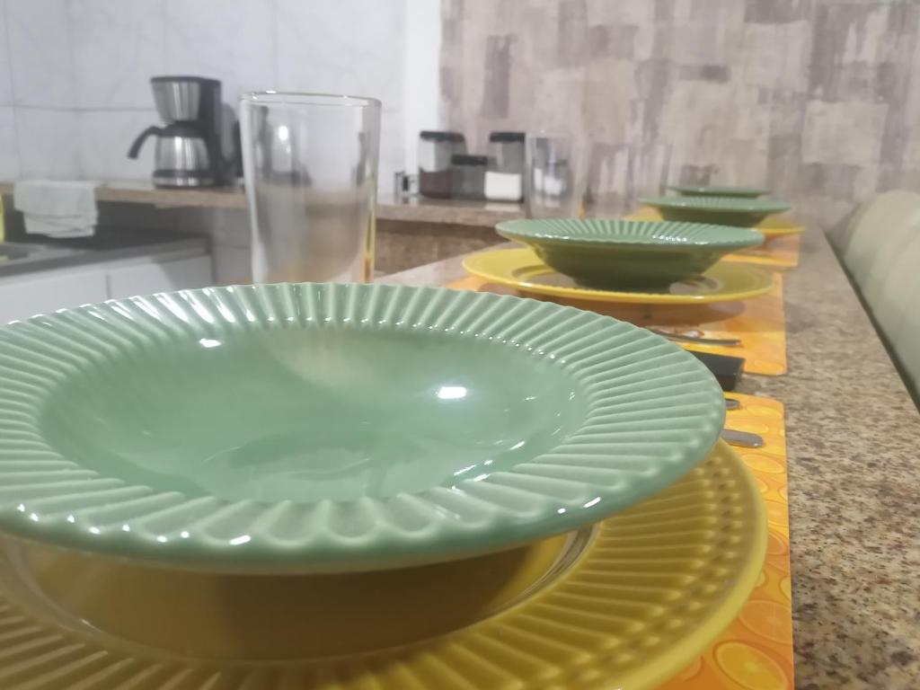 una mesa con platos verdes y cuencos en ella en charmoso apto Centro de Curitiba, en Curitiba