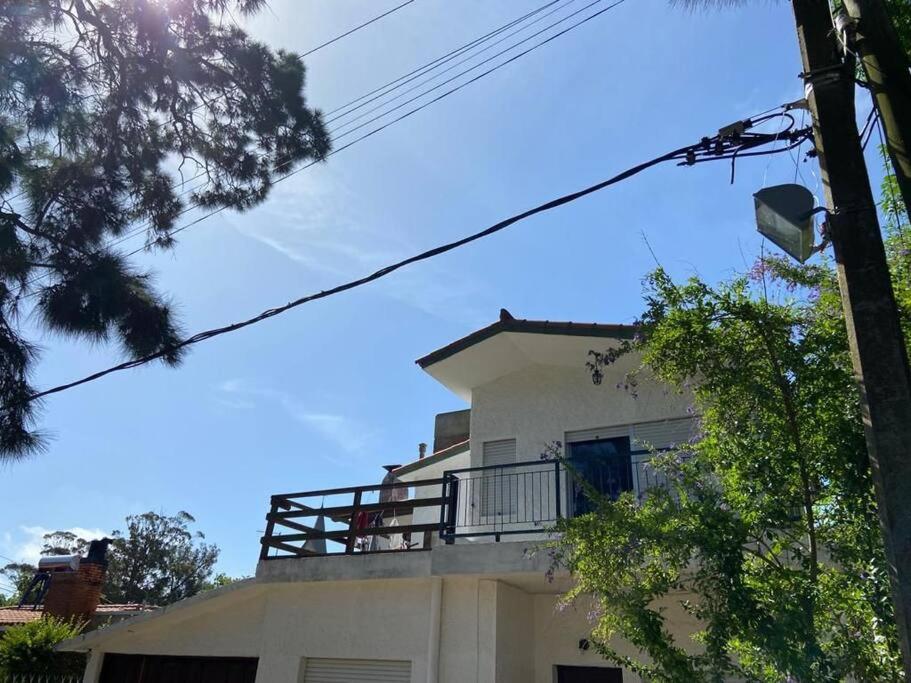 ein weißes Haus mit Balkon darüber in der Unterkunft Hermoso apartamento en el centro de Atlántida in Atlántida
