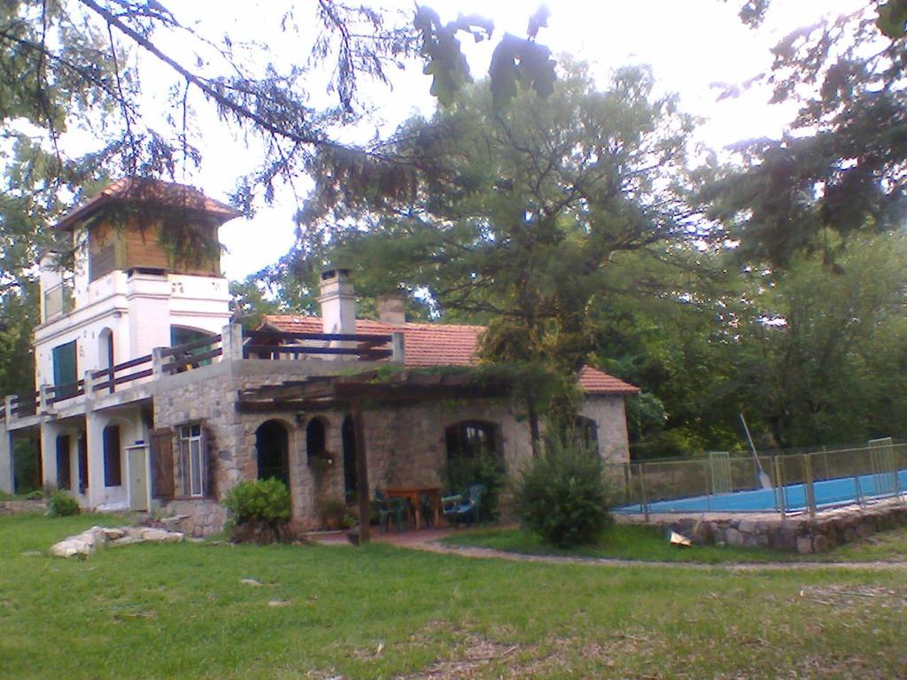 una casa con piscina frente a ella en Casa Soleares en Villa Las Rosas