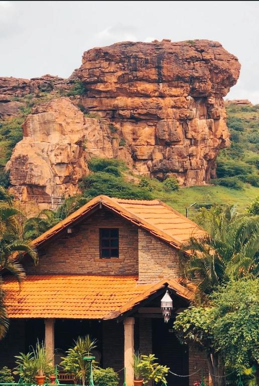 a house in front of a rocky mountain at BADAMI HERITAGE RESORT in Badami