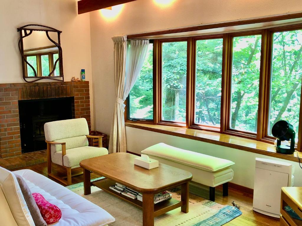 a living room with a couch and some windows at Cottage 62 Seseraginomori Kyu-karuizawa in Karuizawa