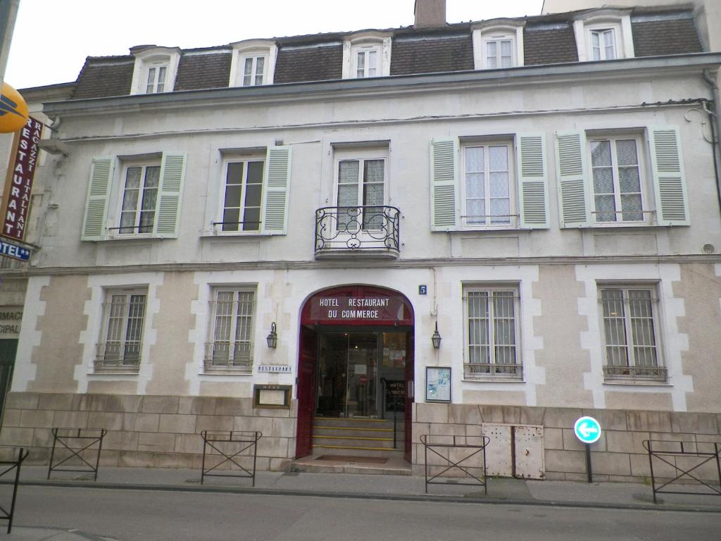 a red brick building with a clock on the front of it at Hôtel du Commerce in Auxerre