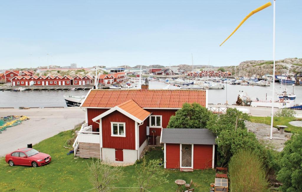 une maison rouge avec une voiture rouge en face d'un port de plaisance dans l'établissement 2 Bedroom Stunning Home In Rnnng, à Rönnäng