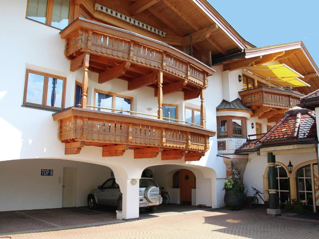 キルヒベルク・イン・チロルにあるHoliday home in Kirchberg with saunaの木製バルコニー付きの建物、正面に駐車した駐車場