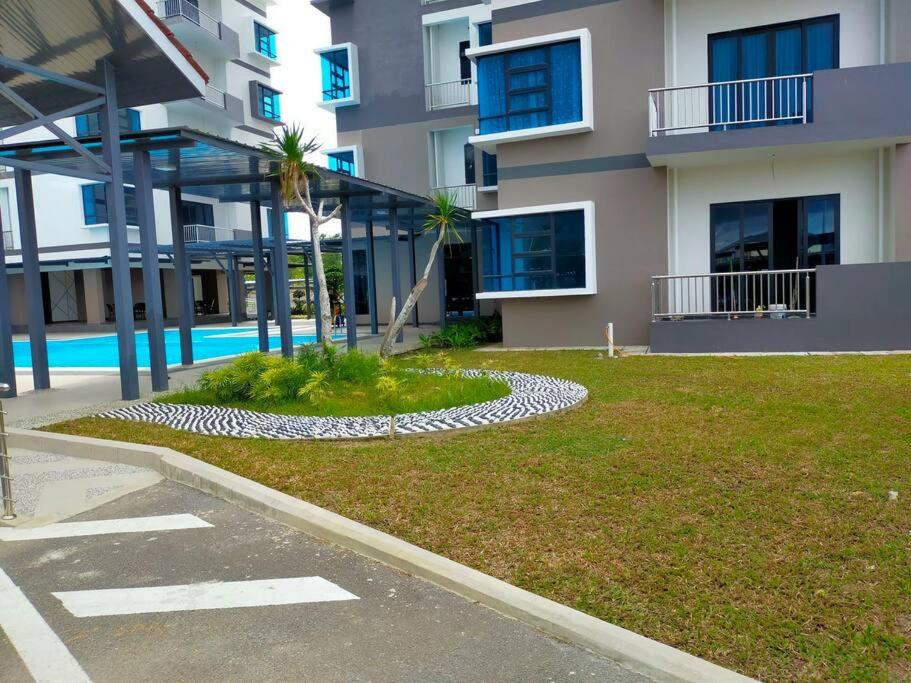 a building with a grassy yard in front of a building at Sunsky Condominium Homestay in Miri