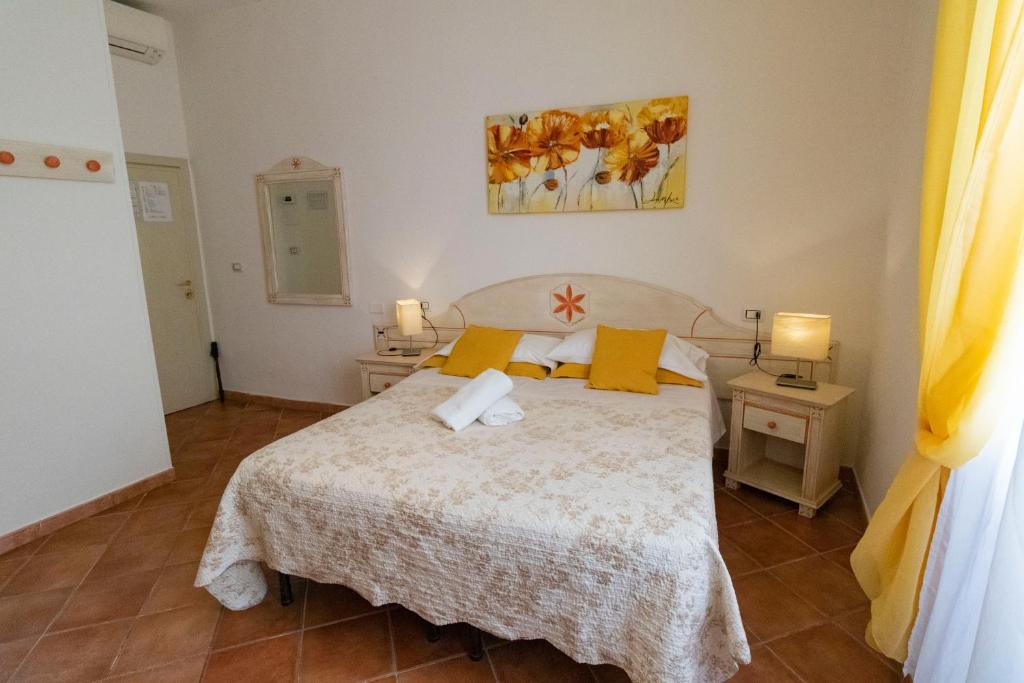 a bedroom with a bed with yellow pillows at Cicerone Guest House in Florence