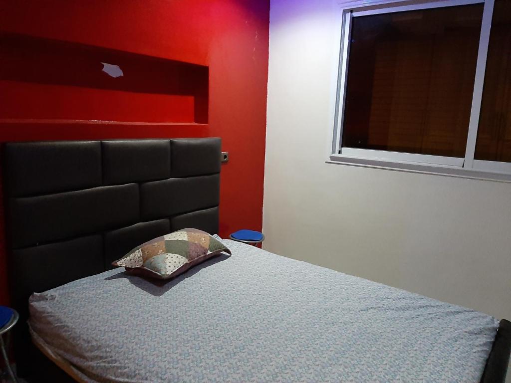 um quarto com uma cama com uma cabeceira preta e uma janela em Villa 1299 em Plage de Mehdia