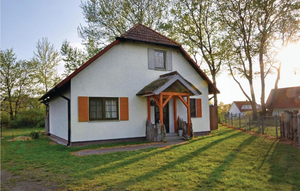 ein kleines weißes Haus mit rotem Dach in der Unterkunft Ferienhaus Hafenstr. 6 / FH M in Fuhlendorf