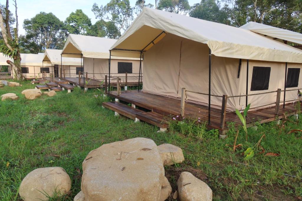 a large tent in a field with some rocks at Canopy Villa Nuang Hill in Bentong