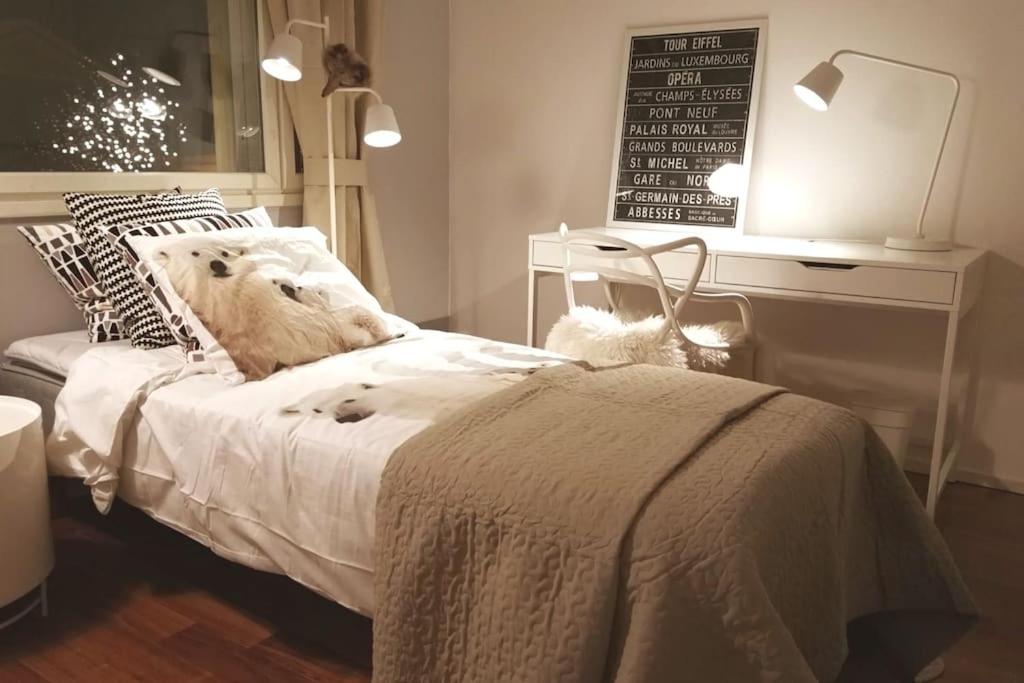 um quarto com uma cama branca e uma mesa em Arctic Circle Luxury House em Rovaniemi