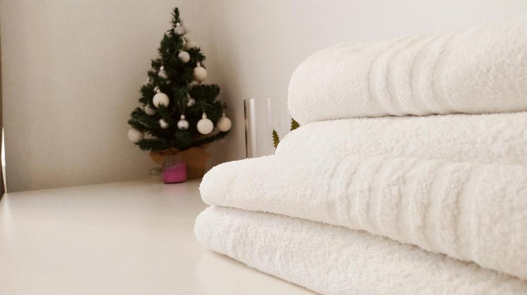 a christmas tree sitting next to a pile of towels at Modern Room with private bathroom in Trento
