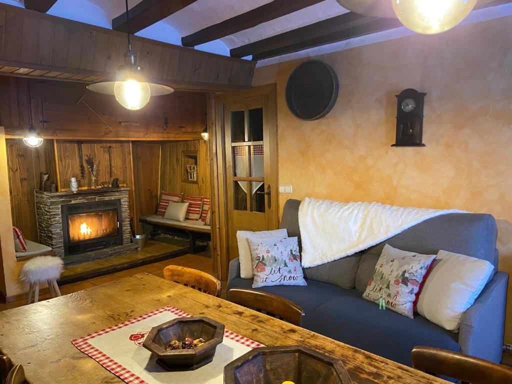 a living room with a couch and a table and a fireplace at CASA DONDELA in Roní