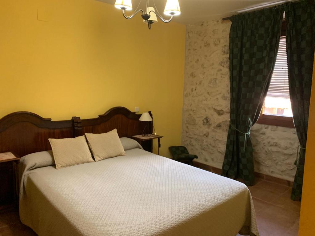 a bedroom with a bed and a window at MolinoGrande del Duratón in San Miguel de Bernúy