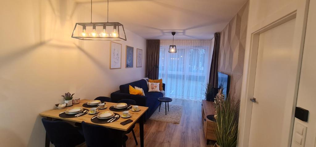 a living room with a table and a couch and a dining room at Apartament MAG in Bielsko-Biała