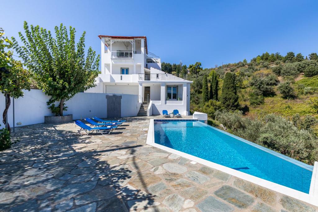 une villa avec une piscine et une maison dans l'établissement Villa Pasifika, à Loutrákion