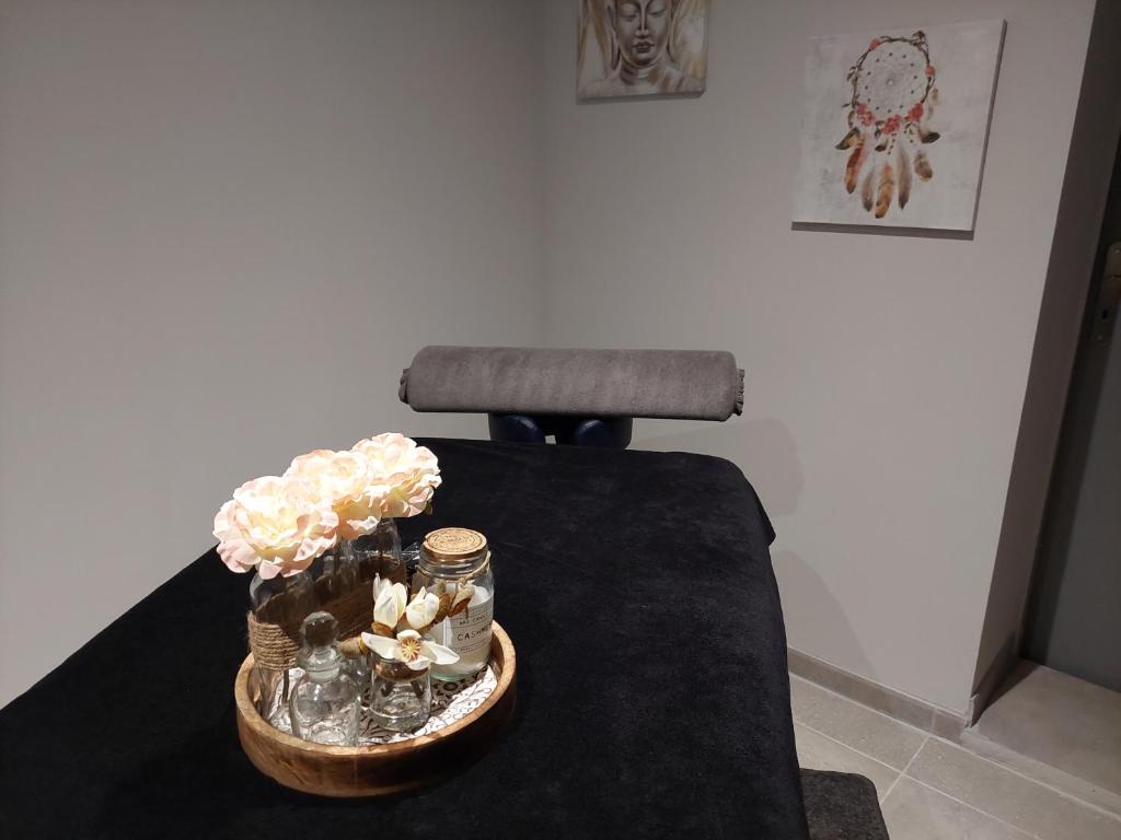 a table with a vase of flowers and a chair at gite A L' ÉVIDENCE in Mornas