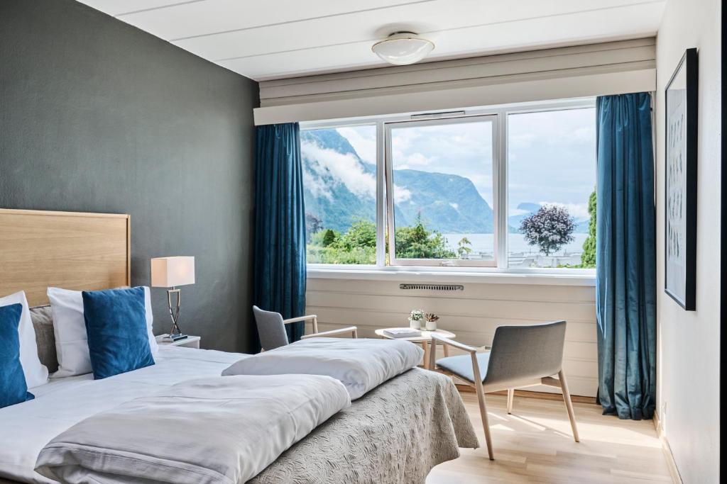 um quarto de hotel com uma cama grande e uma janela em Skjolden Hotel em Skjolden
