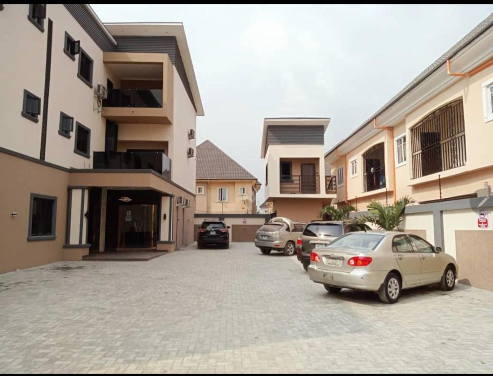 ein Parkplatz mit Autos vor einem Gebäude in der Unterkunft The Charis Hotel & Suites in Port Harcourt