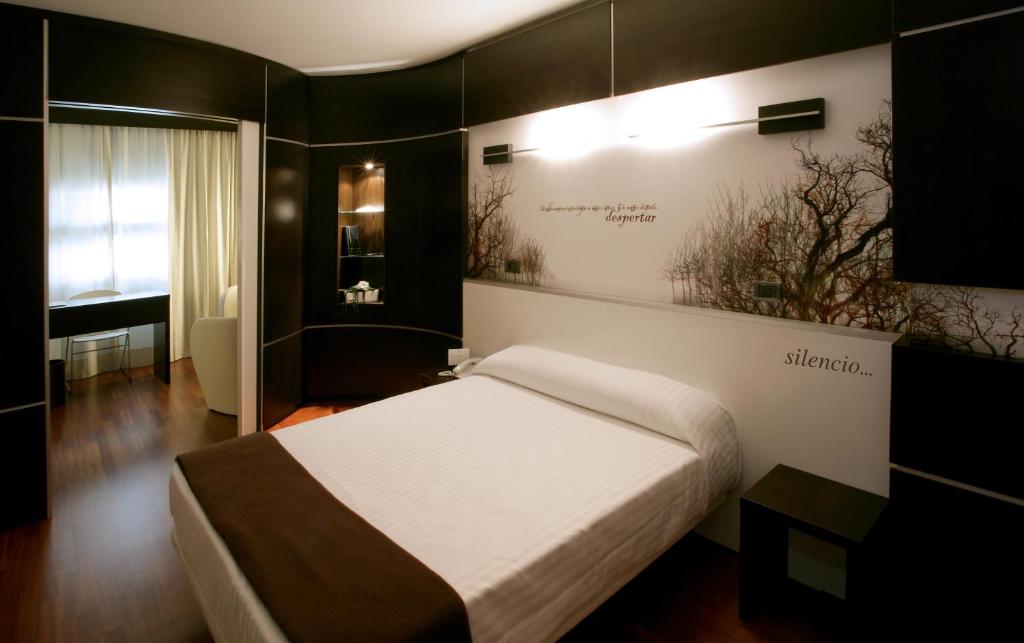 Hotel Europa في أوتيبو: غرفة نوم مع سرير مع علامة على الحائط