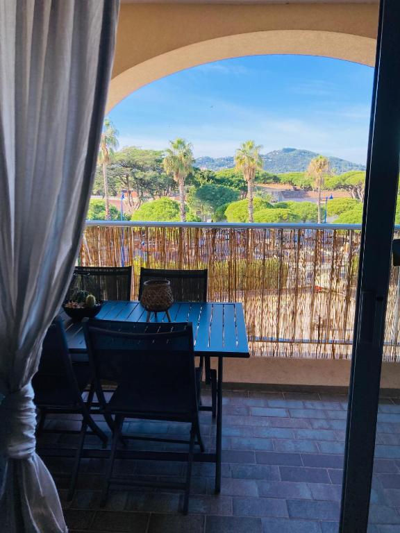 niebieski stół i krzesła na balkonie z widokiem w obiekcie Hyeres port bel appartement w Hyères