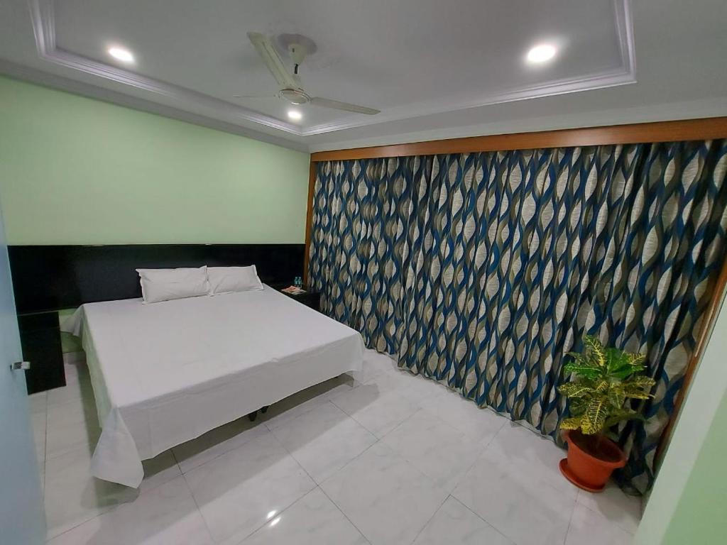 a bedroom with a white bed and a wall at PRIVATE HOME STAY in Secunderabad