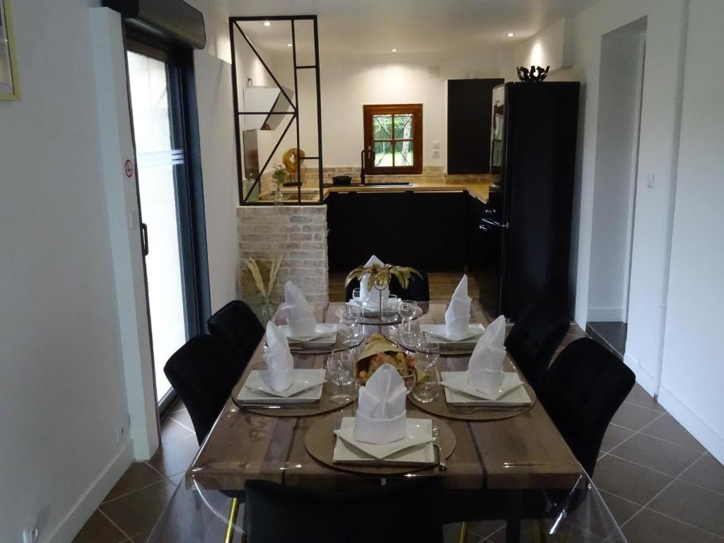 una mesa de comedor con servilletas y platos. en Le Clos de la Déesse, en La Ferté-Saint-Cyr