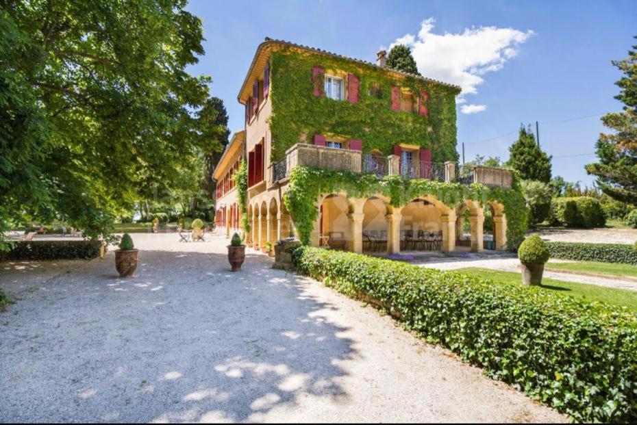 une grande maison avec du lierre sur son côté dans l'établissement Suite le Quervalat dans magnifique bastide 18eme, à Aix-en-Provence