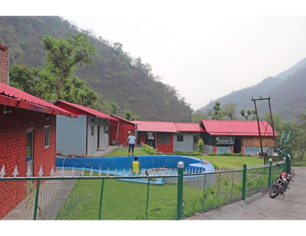 a man is standing in front of a swimming pool at Hotel Jungle View Resort, Bhogpur in Kandogal