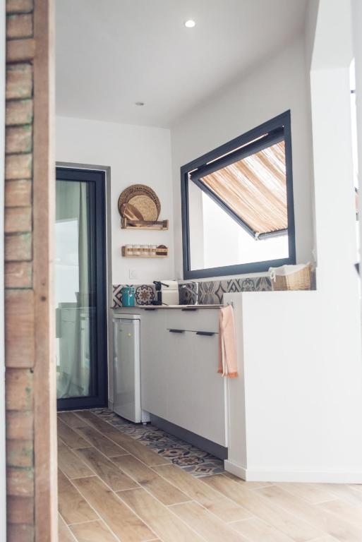 eine Küche mit einem Kühlschrank und einem Fenster in der Unterkunft T1 Villa Romantique Reve d'ailleurs St Leu in Saint-Leu