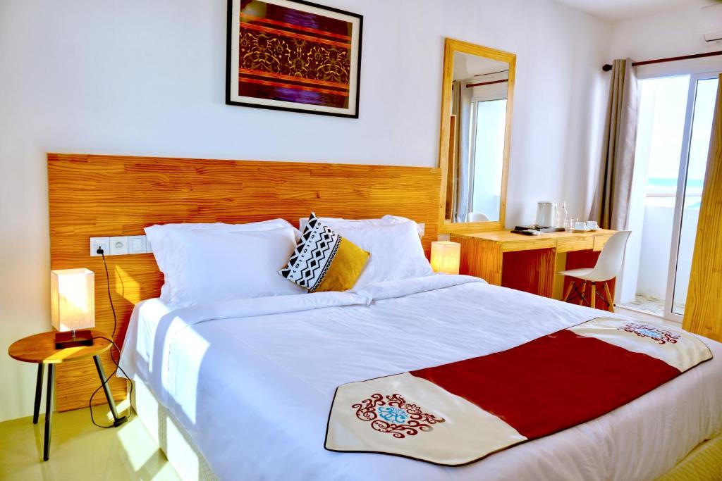 1 dormitorio con 1 cama grande con manta roja y blanca en Island Ambience en Maafushi
