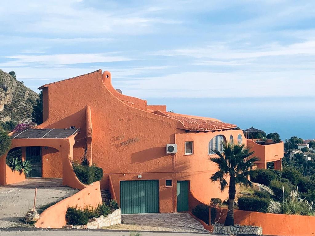 een oranje huis met een palmboom ervoor bij La Morada in Altea