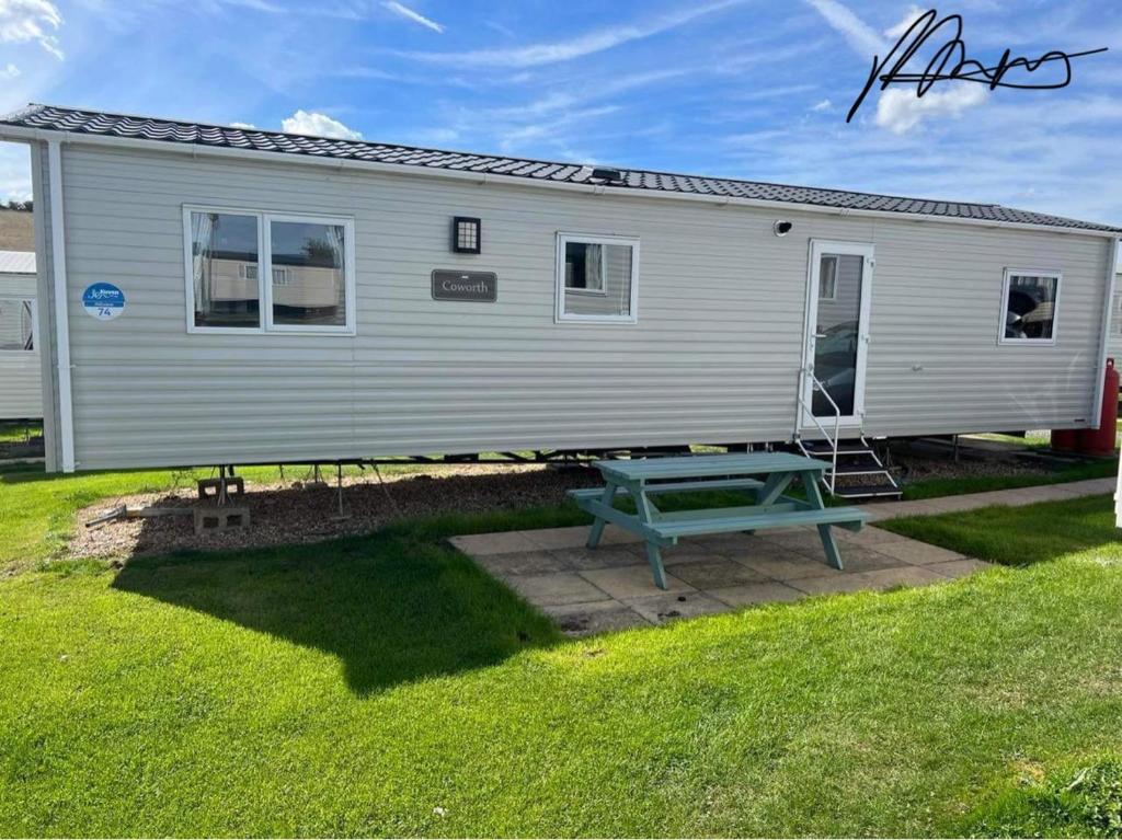 a mobile home with a picnic table in a yard at Weymouth bay haven in Preston