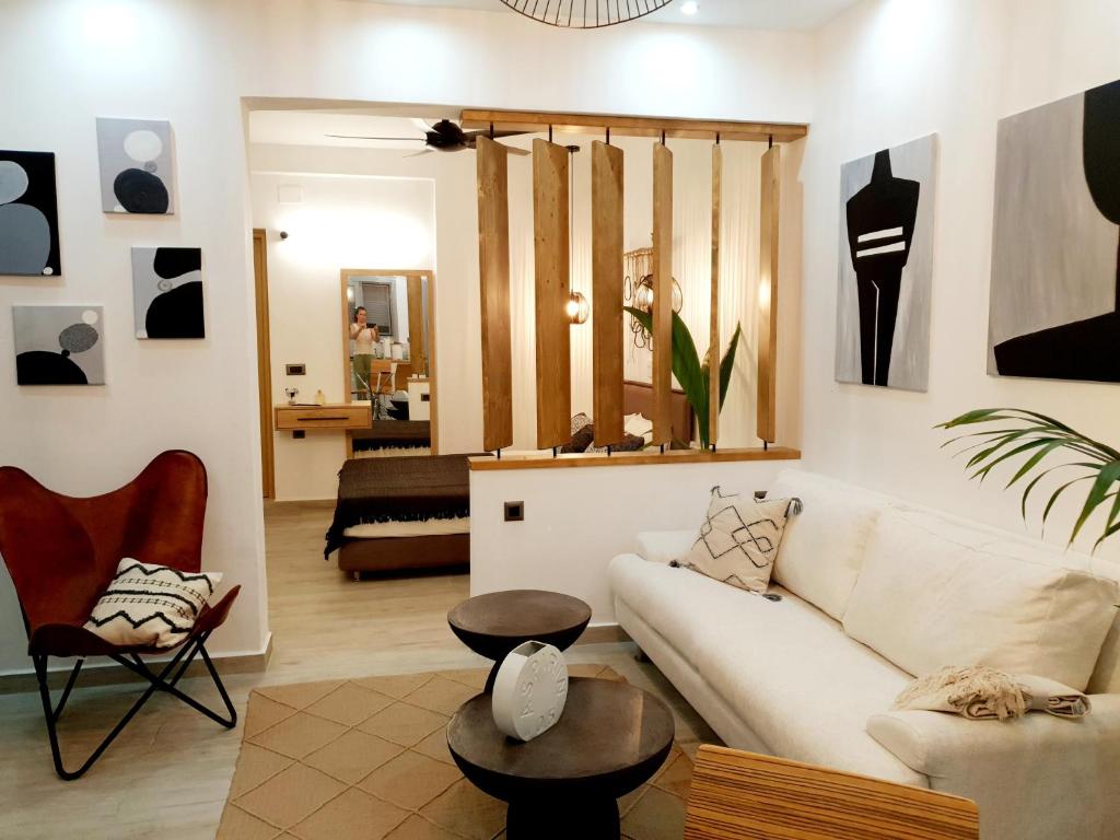 ein Wohnzimmer mit einem weißen Sofa und einem Tisch in der Unterkunft Costa Bianco Luxury Home in Agios Nikolaos