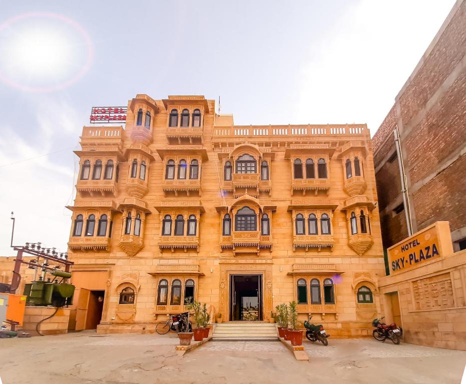 een groot oranje gebouw met motoren ervoor geparkeerd bij Hotel Sky Plaza - Best ever view of Jaisalmer Fort in Jaisalmer