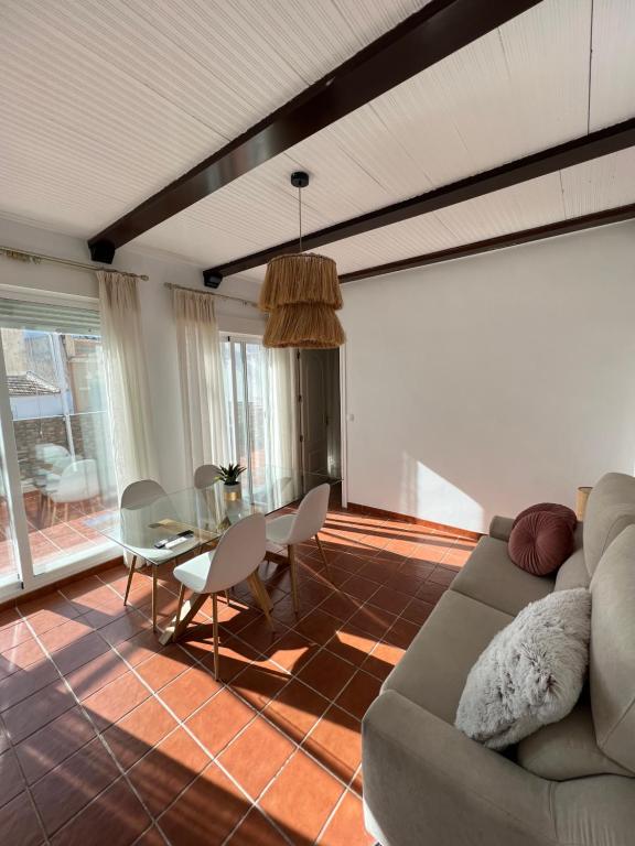 Una sala de estar con un sofá, una mesa y sillas. en BALCÓN DE CLAUDIO MARCELO, en Córdoba