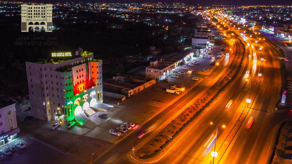 una vista aérea de una ciudad por la noche con luces en عبري كاسل هوتيل, en Ibri