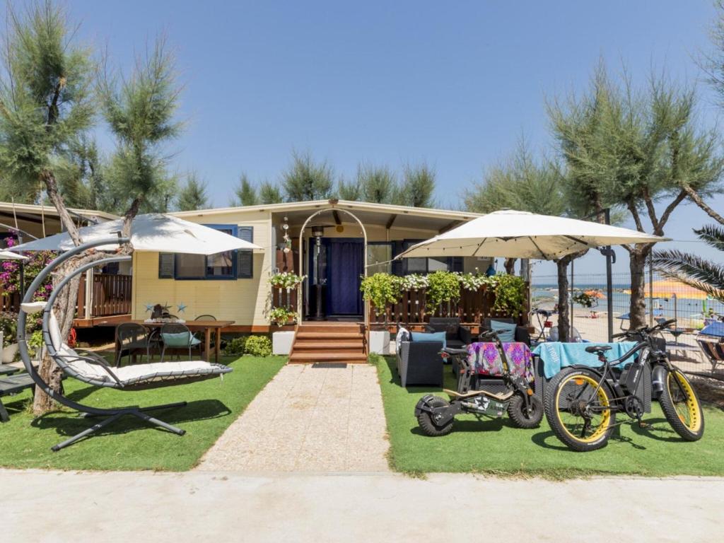 una casa sulla spiaggia con biciclette e ombrelloni di Pleasant holiday home in Cupra Marittima with garden a Cupra Marittima