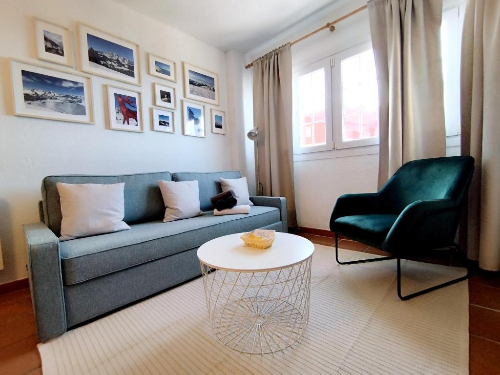 a living room with a blue couch and a table at Apartamentos Arttyfal con parking y WiFi by SURYNIEVE in Sierra Nevada