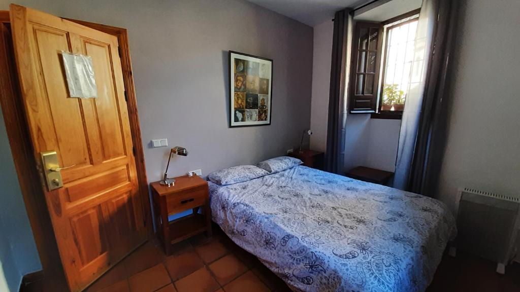 um quarto com uma cama e uma porta de madeira em Ronda em Ronda