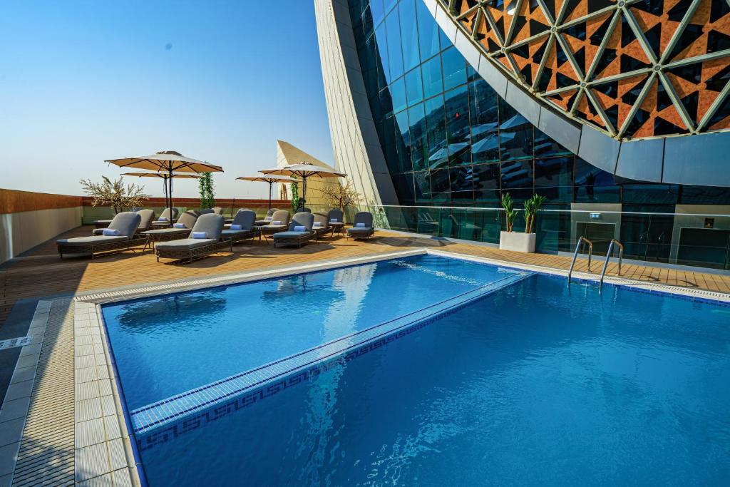 a large swimming pool in front of a building at Velero Hotel Doha Lusail in Doha