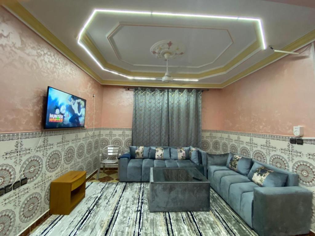 uma sala de estar com um sofá e uma televisão em coop auberge trt em Taourirt