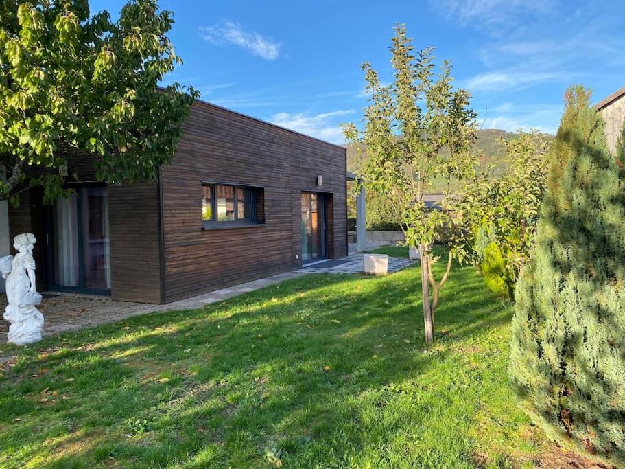 uma casa de madeira com um quintal em frente em Chez Nono em Mitzach