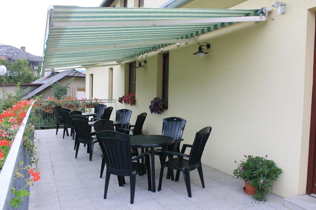 una fila de sillas y mesas negras en un patio en Penzion Fialka, en Velké Losiny