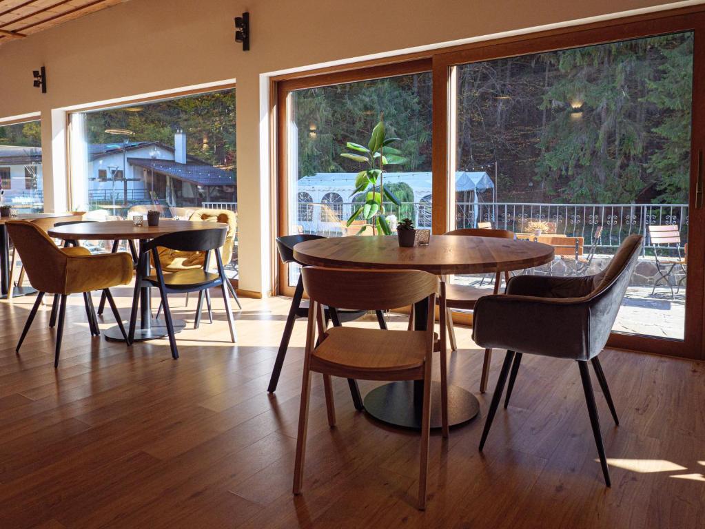 un restaurante con mesas y sillas y una gran ventana en EKOREZORT VENDELIN, 