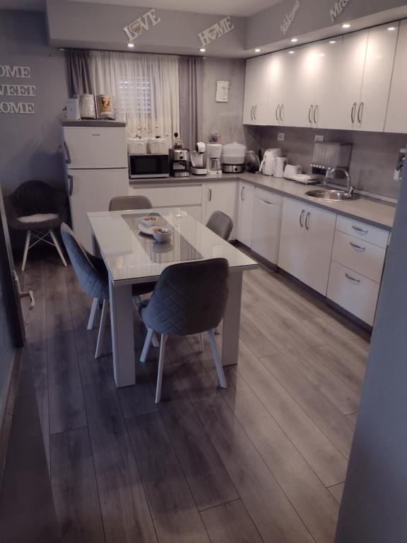 a kitchen with white cabinets and a table and chairs at Mare kuća za odmor in Šibenik