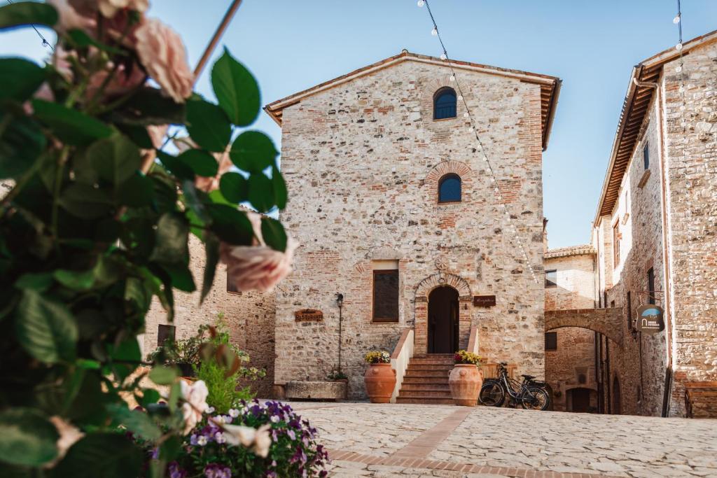 een gebouw met een klokkentoren op een binnenplaats bij Borgo Petroro in Todi