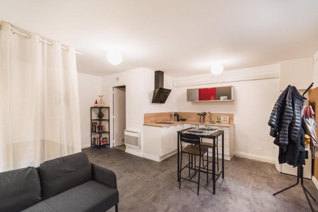 a living room with a couch and a kitchen at Studio Hyères Médiéval in Hyères