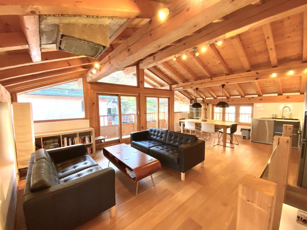 a living room with leather couches and a table at Chalet Greuffa in Courchevel