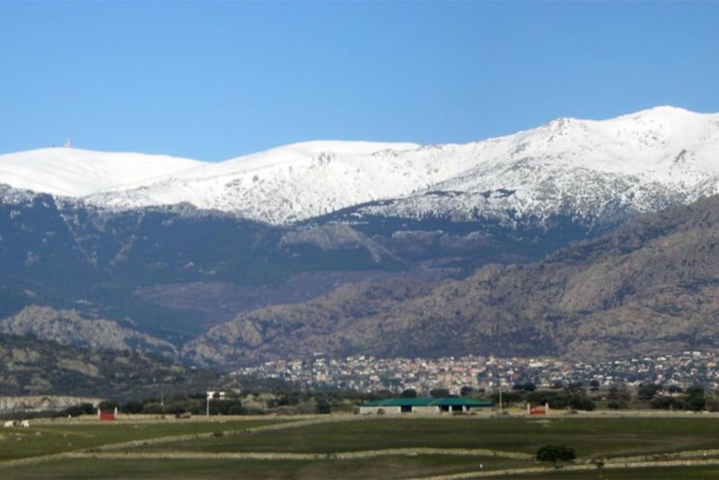 una cordillera cubierta de nieve con una ciudad en un campo en Loft near mountain range. 30 minutes to Madrid, 